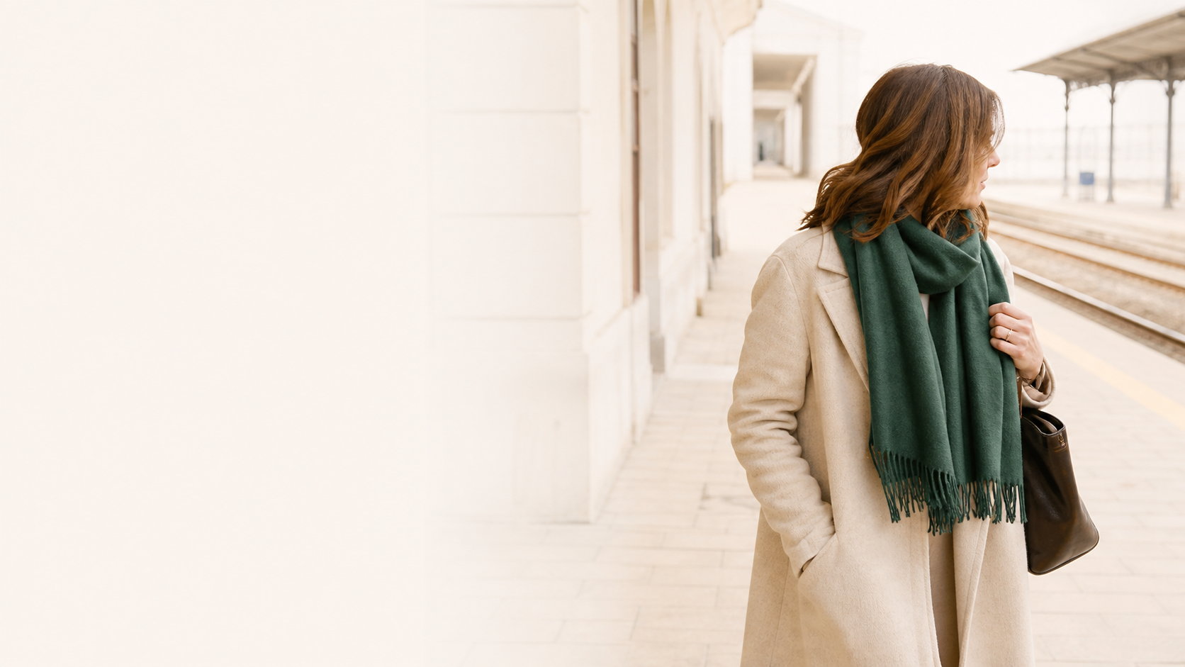 Woman wearing a cashmere scarf at a bright European railway station